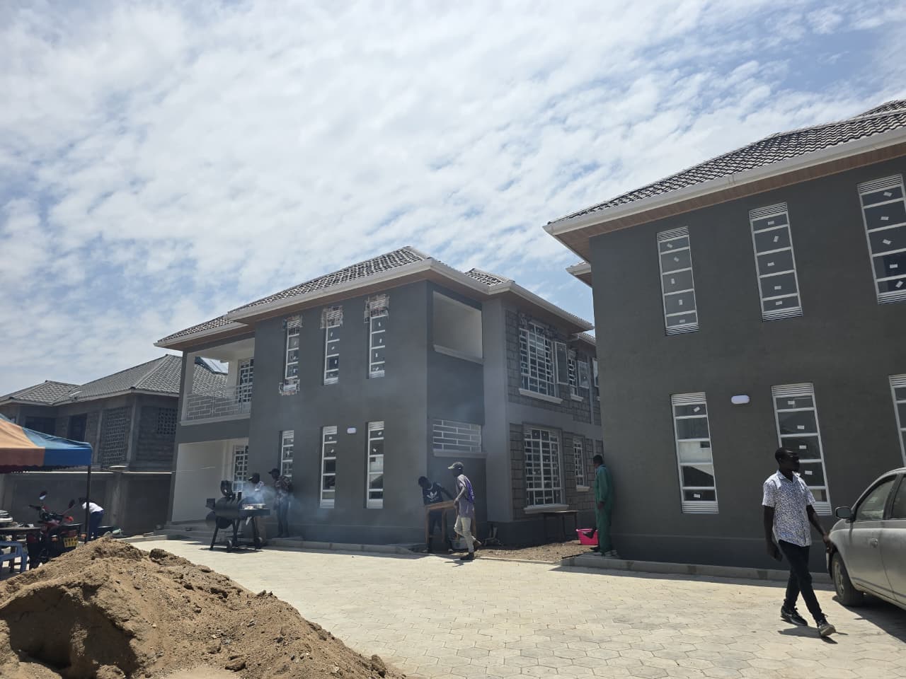 Completed two-storey grey-render rental unit in Katani with tiled hipped roof