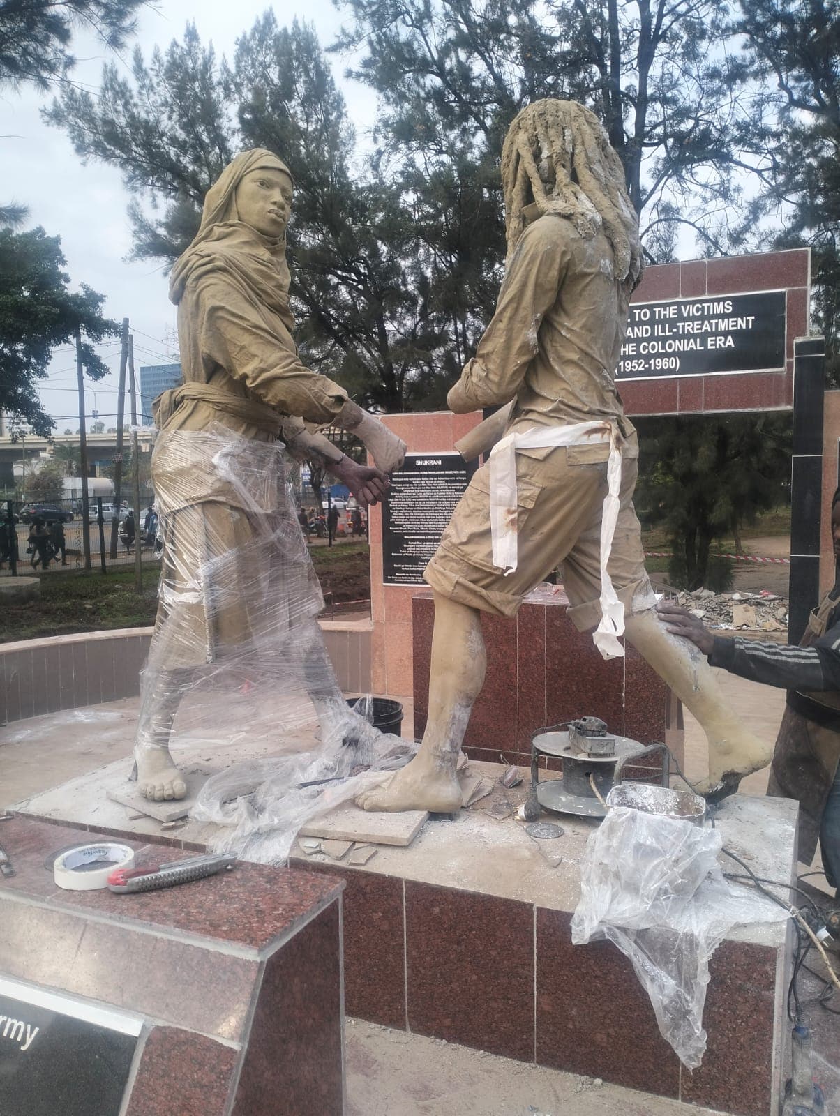 Bronze sculpture group at the Mau Mau Memorial wrapped for protection while restoration works go on around it